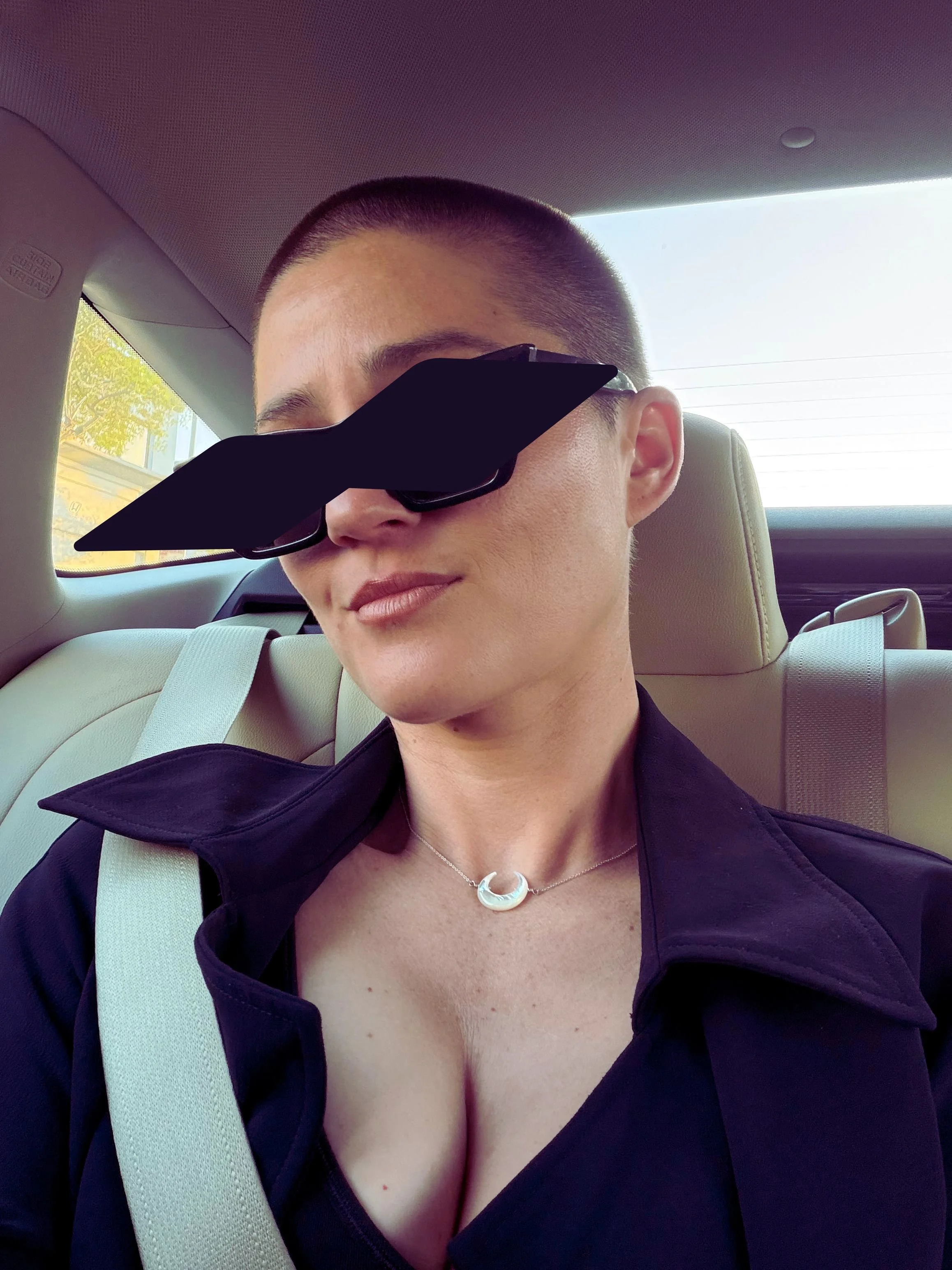 San Francisco Dominatrix portrait with a buzz cut, wearing sunglasses.